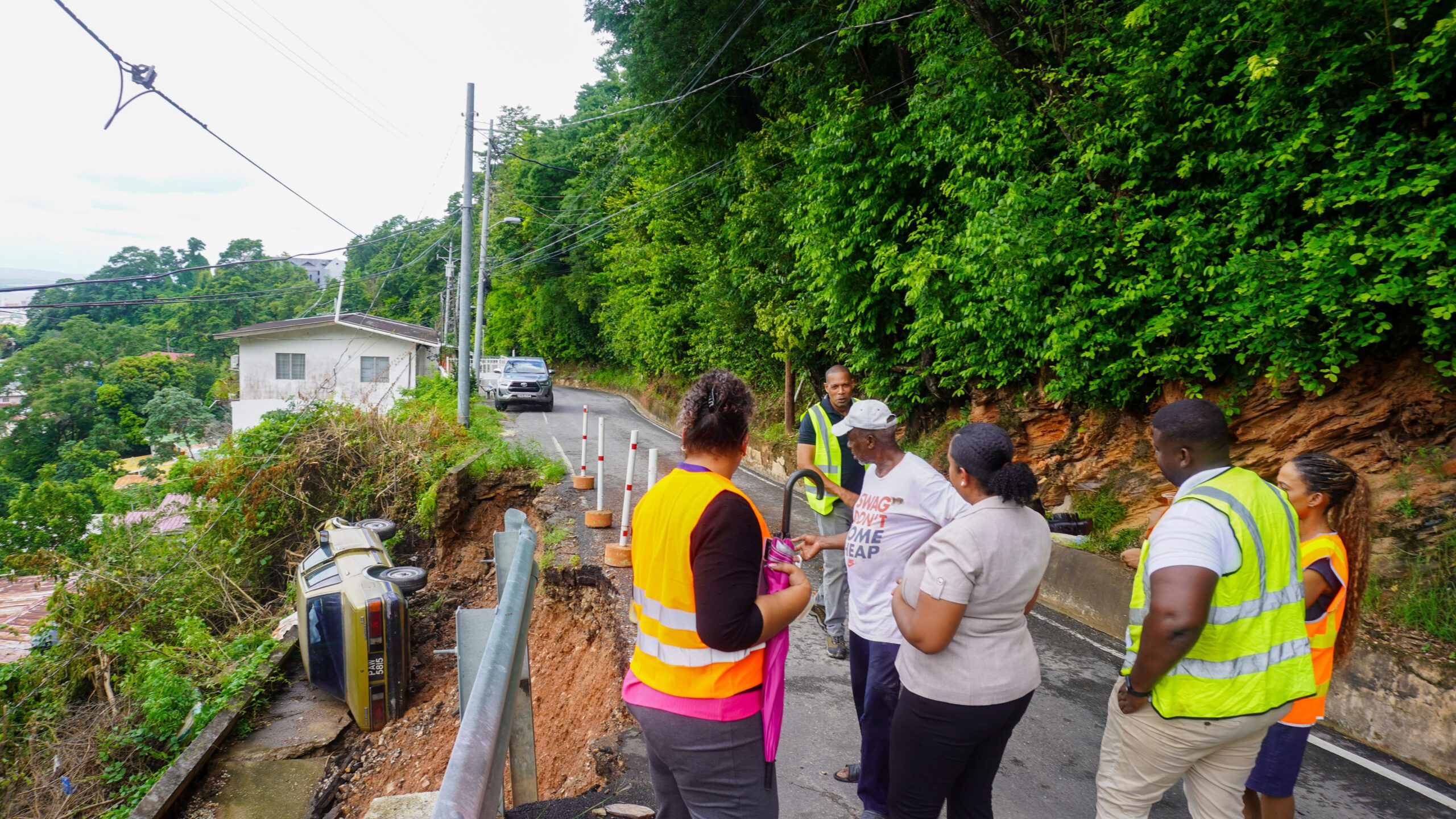Photo 3 Technical experts of the Ministry of Works and Infrastructure at the site of the Fort George Landslip and Resident of Fort George Road Release
